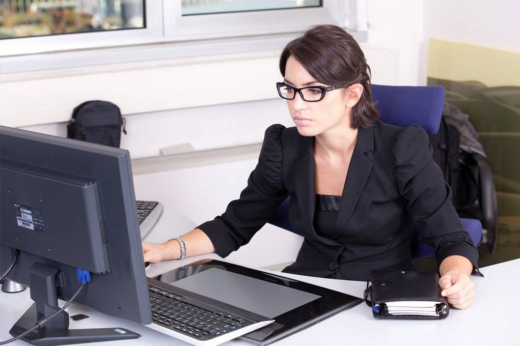 women wearing reading glasses working at computer