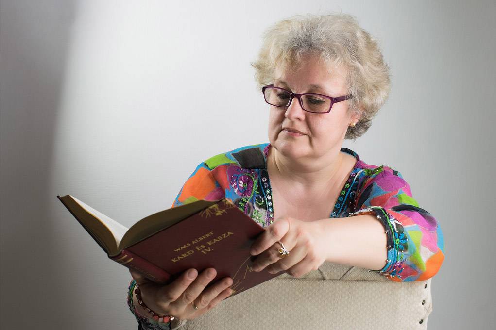 old lady wearing reading glasses and reading a book