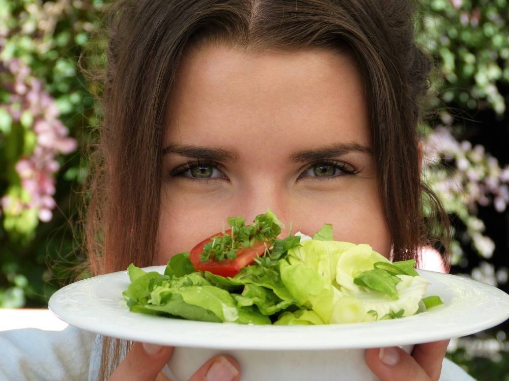 close up of woman's eyes and plate of healthy food