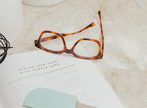 Pair of Réveur lightweight reading glasses sitting on a cookbook